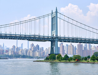 RFK Bridge seen from the East River with the skyline of Manhattan in the background.