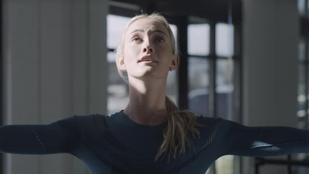 Tilt up to close up of woman practicing spinning in dance studio / Lehi, Utah, United States