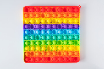 Push Bubble Fidget Toy Pop It on white background. Trendy rainbow anti-stress sensory toy popit for popping bubbles. Flat lay, top view.