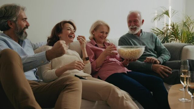 Senior Man Catching Popcorn In Midair At Home Party