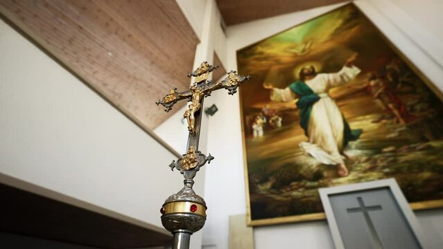 Wide angle view over a large cross against a Jesus Christ icon in a catholic church