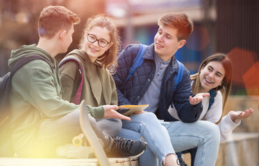 Teenage friends spending time together talking and smiling outdoors