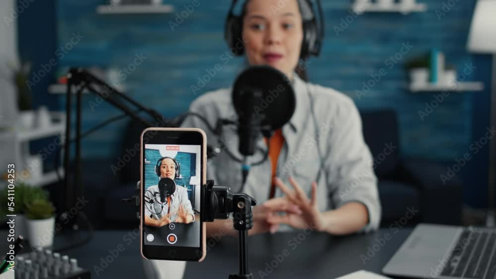 Poster popular internet star using portable computer while streaming remote podcast show on smartphone. cre