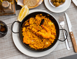 National Spanish rice dish paella tinted with saffron. Prepared with olive oil and seafood