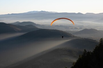 Person doing paragliding over mountains
