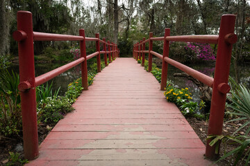 Red foot bridge spanning a swamp
