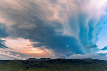 Obraz premium wing like clouds in blue during sunset over the mountains