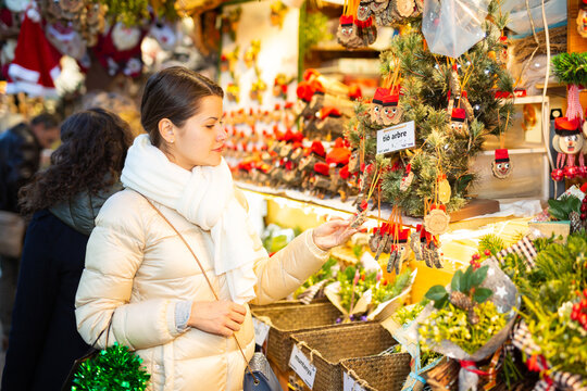 Attractive woman chooses christmas presents on outdoor Christmas market. High quality photo