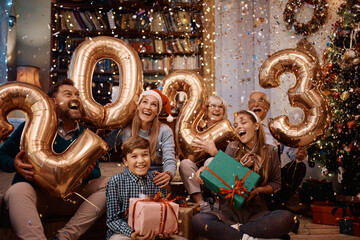 Joyful extended family has fun during New Year's home party filled with confetti's.