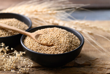 Brown quinoa seed in bowl with spoon on wooden background, Super food