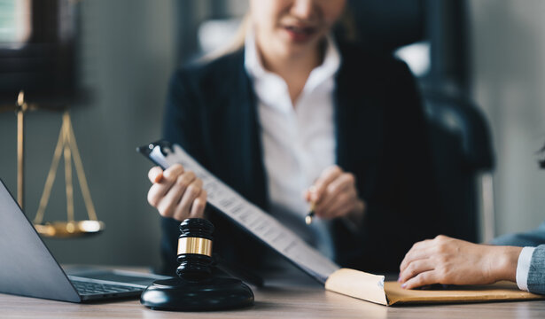 Female Lawyer  Litigation Trial Lawyer office. Statue of Justice with scales and lawyer working on a laptop. Legal law, advice and justice concept.