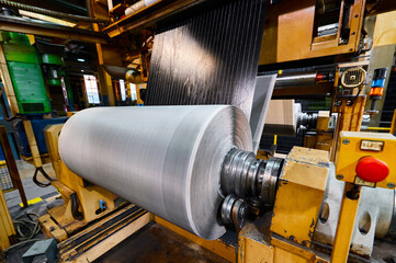 Rolling reinforced sheet on reel drum with rubber band