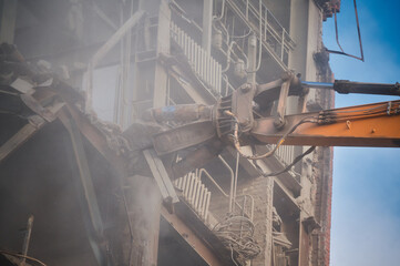 Hydraulic scissors on rig of crane cut building on site