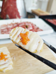 Pick Sweet egg roll sushi with mayonnaise sauce With Chopsticks.