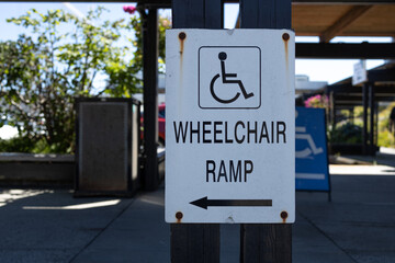 View of directional sign Wheelchair Ramp attached to the fence