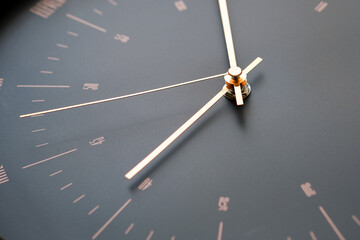 The black wall clock has gold hands that look elegant and modern.