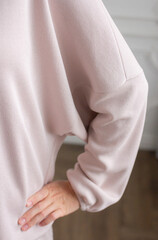 Pink sweater textile close up with woman hand