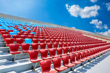 Fototapeta premium Red seats and beautiful sky clouds in the stadium