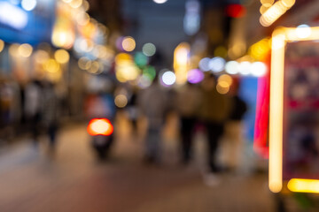 Blurred view of Seoul street with modern buildings, pavements and stylish people walking. Can be used as background. De focused image of capital of south Korea at night
