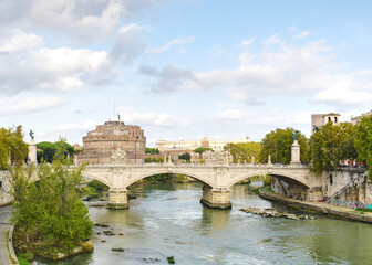 Obraz premium The Saint Angelo bridge spanning the Tiber river in Rome Italy as seen on a fall day.