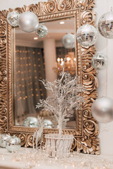 Beautiful golden mirror on the bedside table with Christmas decorations