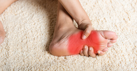 Asian woman feeling pain in her foot at home