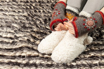 Fluffy woolen booties and mittens. Warm woolen clothes.