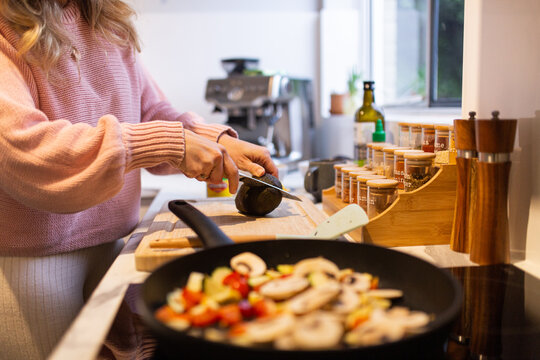 Woman cutting an avocado as she prepares dinner