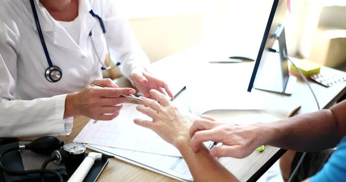 Male patient scratches his hand at doctor appointment