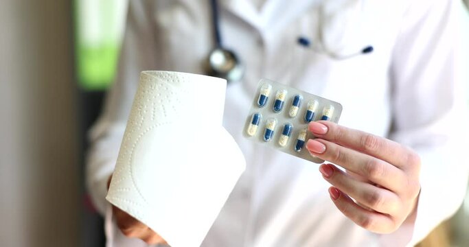 Doctor is holding pills and toilet paper in hand