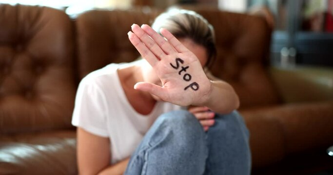 Curious woman showing stop gesture with hand with stop text