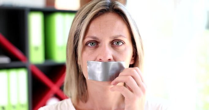 Portrait Of Beautiful Woman Removing Tape From Her Mouth