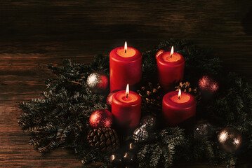 four burning Red advent candles in advent wreath decoration on wooden dark background. tradition in time before Christmas. xmas lights with christmas fir deco background concept. Festive still life.