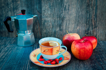 A cup of tea, rose hips, apples and a kettle. Vitamins, disease prevention