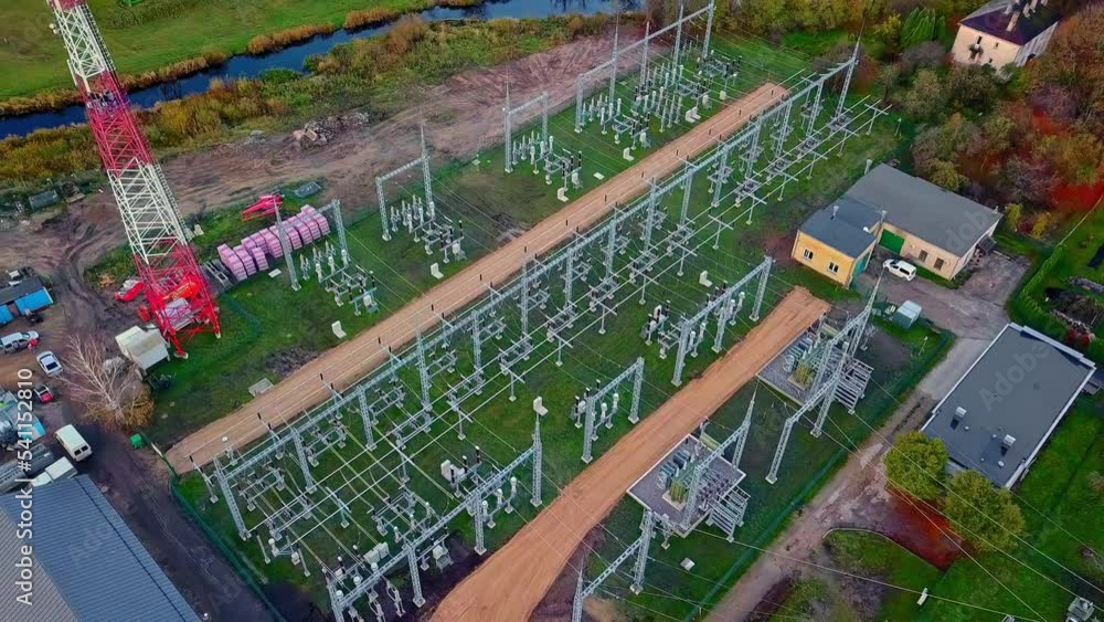 Poster aerial view of transformers in a newly built electricity substation at daytime. drone pullback tilt-