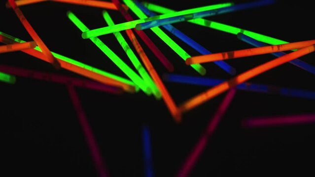 Abstract camera moves left across neon colour glowing sticks on black