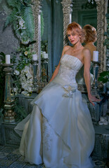 bright girl with a fashionable hairstyle in a white dress in an entourage studio