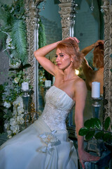 bright girl with a fashionable hairstyle in a white dress in an entourage studio