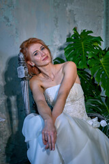 bright girl with a fashionable hairstyle in a white dress in an entourage studio