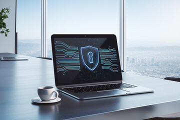 Close up of laptop computer on desk with coffee cup and abstract glowing secure web safety and protection hologram on office interior with window and city view background.
