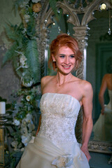 bright girl with a fashionable hairstyle in a white dress in an entourage studio