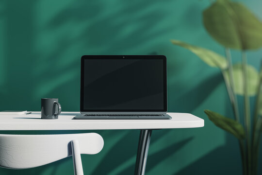 designer office desktop with empty laptop screen with mock up place in frame, green wall background with sunlight and shadows, blurry decorative plant and coffee cup. 3D Rendering.