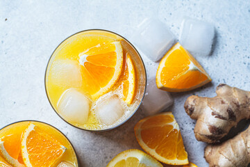 Orange lemon juice with ginger and spices in glass, gray background. Immunity boosting drink,...