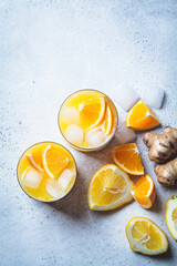 Orange lemon juice with ginger and spices in glass, gray background. Immunity boosting drink,...