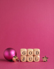 Small wooden blocks with the inscription God Jul, Scandinavian Merry Christmas, purple background