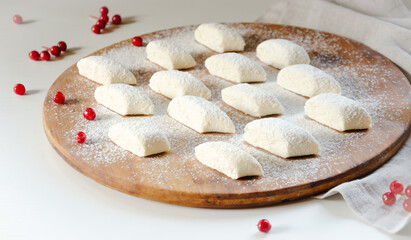 preparation of lazy dumplings from cottage cheese laid out on a wooden board