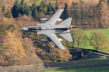 Tornado GR4 Fighter jet flying fast low level in the Mountains of the Lake District, United Kingdom. RAF pilot and navigator topside view