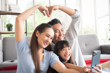 Happy family sitting together and take a photo selfie with smile emotion in living room.