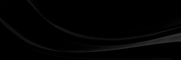 Black gray satin dark fabric texture luxurious shiny that is abstract silk cloth background with patterns soft waves blur beautiful.