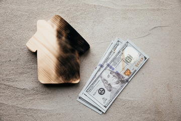 A dollar bills and a burn house. Collapse, crisis, sale or destruction of a home